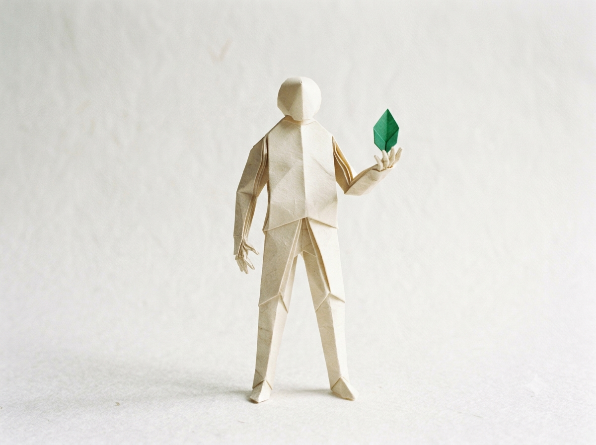 Origami-Figur selbstbewusst stehend, ein grünes Blatt in der Hand: Symbol für den eigenen Weg